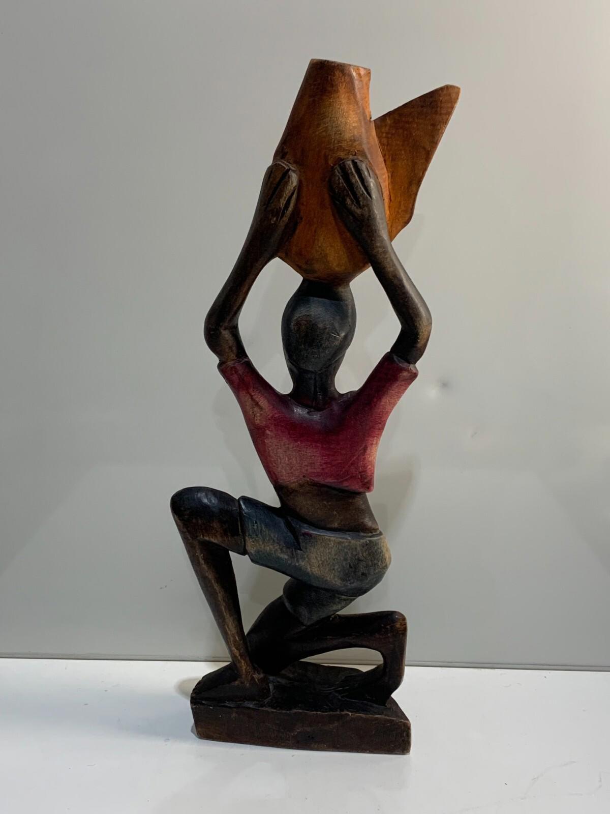 Figurine ancienne en bois sculpté à la main d’une femme africaine agenouillée tenant un panier