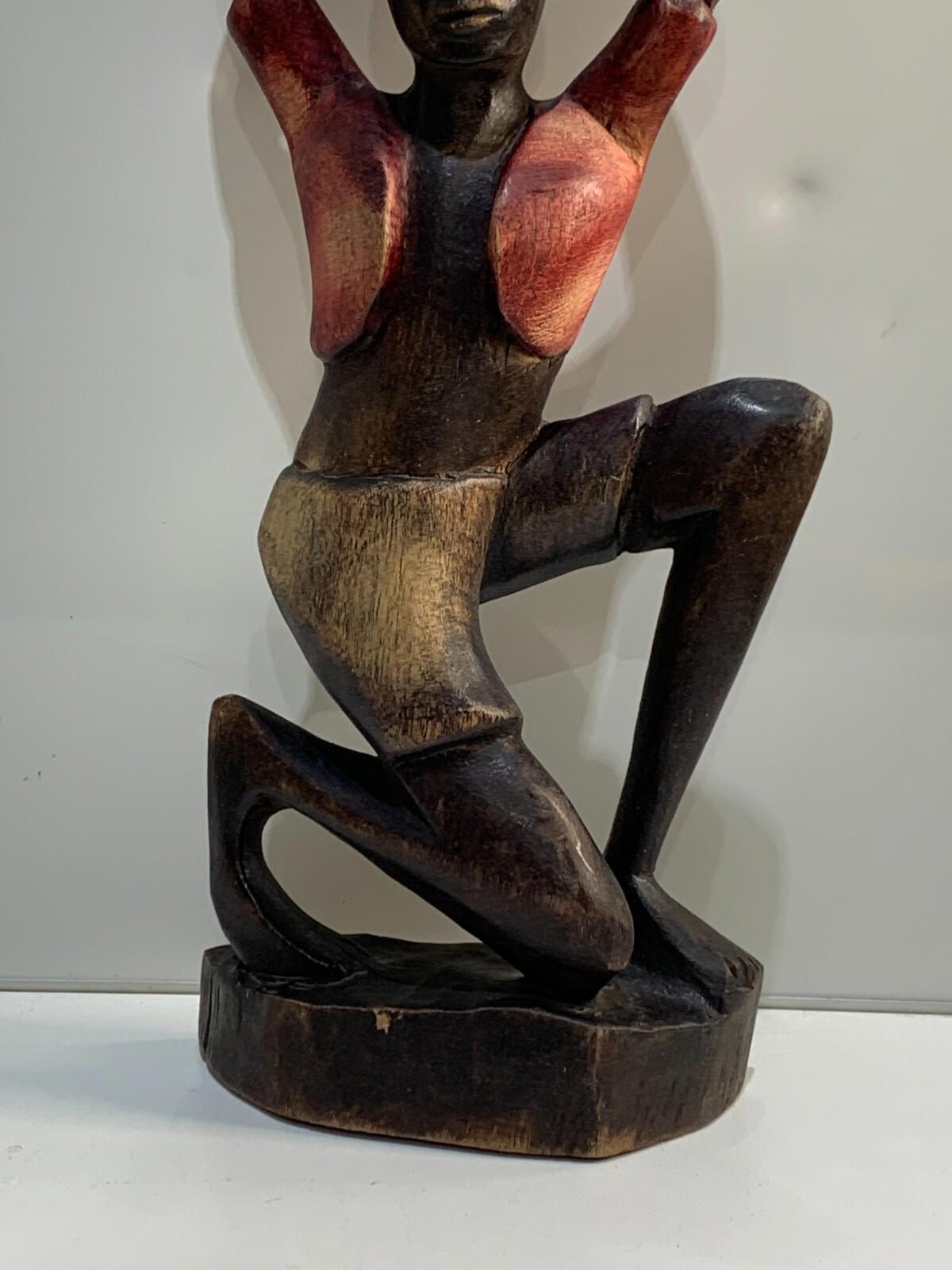 Figurine ancienne en bois sculpté à la main d’une femme africaine agenouillée tenant un panier